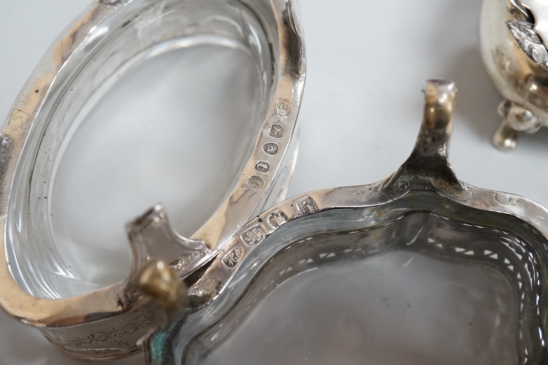 A pair of George III pierced silver shaped oval salts by Hester Bateman, London, 1783 (a.f.), with clear glass liners, together with one other George III silver oval salt, London, 1783 and two later silver mustard pots.